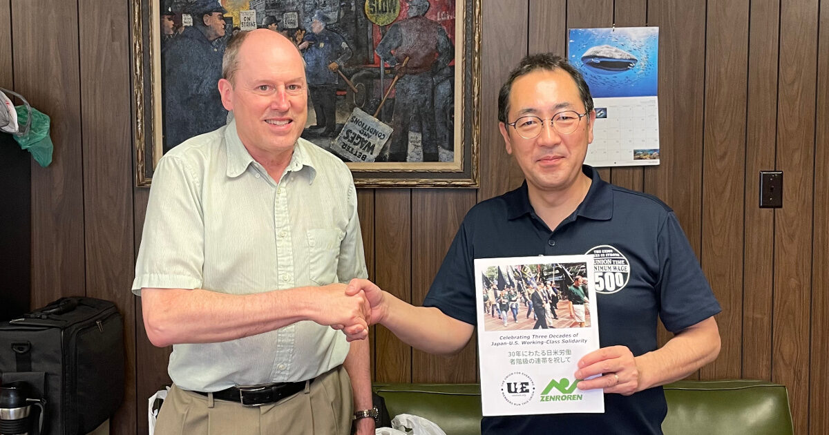 UE General President Carl Rosen presenting a copy of the UE-Zenroren scrapbook to Zenroren Secretary General Koichi Kurosawa